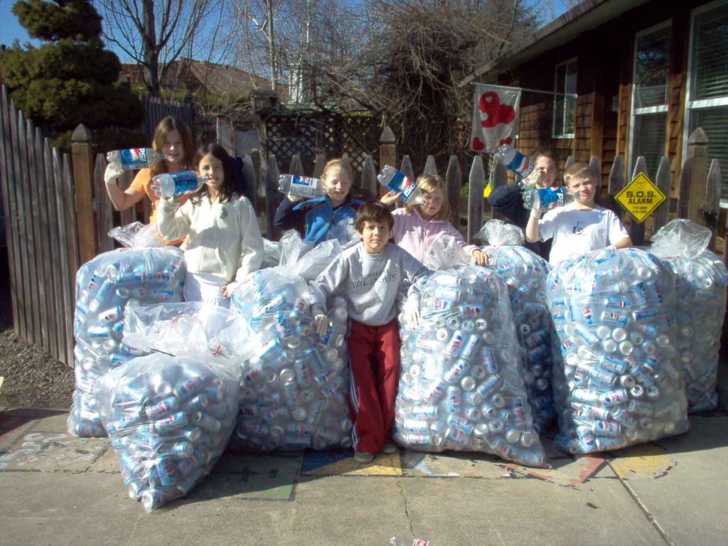 Group of kids with giant, clear bags holding empty soda cans collected to raise money for their Sparrow.